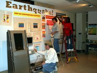 Mark Steed, Exhibit Specialist for the Arkansas State University Museum, together with Sign Shop staff Jerilyn Miller and Kaye Childs, puts finishing touches on the newest exhibit at the ASU Museum.  Entitled Earthquake!, the exhibit was designed by ASU Museum curator Julie K. MacDonald.