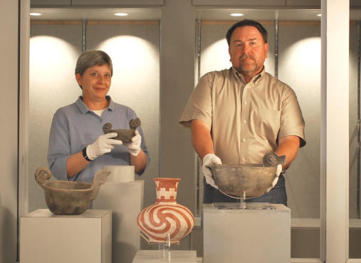 Heritage Studies PhD students Leslie Hester, left, and Marlon Mowdy display rarely seen examples of Native American pottery from the exhibition, "Portals of the Soul," opening at the ASU Museum on Thursday, July 16, as part of the three-day celebration, "Our Awesome Ancestors: Celebrate Human Ingenuity."
