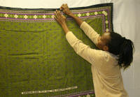 Rose Ong'oa works on the exhibit, "Wearing What Cannot Be Spoken," openig at the ASU Museum on Friday, Feb. 1.