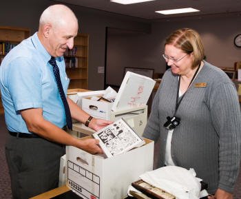 Dr. Joel Gambill, left, and archivist Malissa Davis examine a box of John Robert Starr's papers, a major historical gift to Arkansas State University's Department of Archives and Special Collections. Starr was former Associated Press Bureau Chief in Little Rock and became managing editor of the Arkansas Democrat in 1978, where he wrote a daily column. Starr died in 2000.