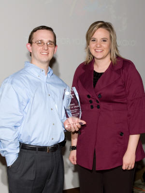 Graphic designers Heath Kelly (left) and Mary Williams hold the “Best of Show” award presented by the NEA Advertising Federation to ASU’s Publications and Creative Services department for producing the University Advancement Case Statement. 