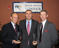Markham Howe, director of International Student Services, Tugrul Polat, and Provost Dan Howard, show the Prism awards won by ASU.