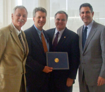 From left, U. S. Representative Vic Snyder, Dr. Len Frey, U.S. Senator Mark Pryor, and Under Secretary for Commerce for International Trade Francisco Sanchez are photographed at the Clinton Presidential Library.